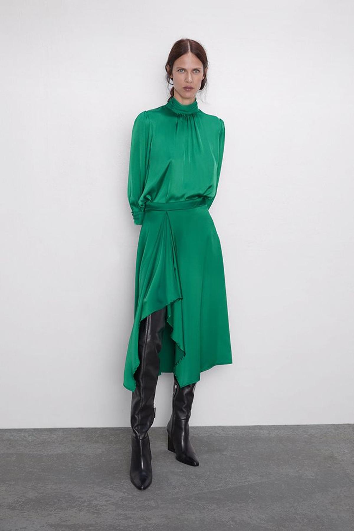 Conjunto formado por blusa de cuello alta y falda asimétrica de satén verde, de Zara
