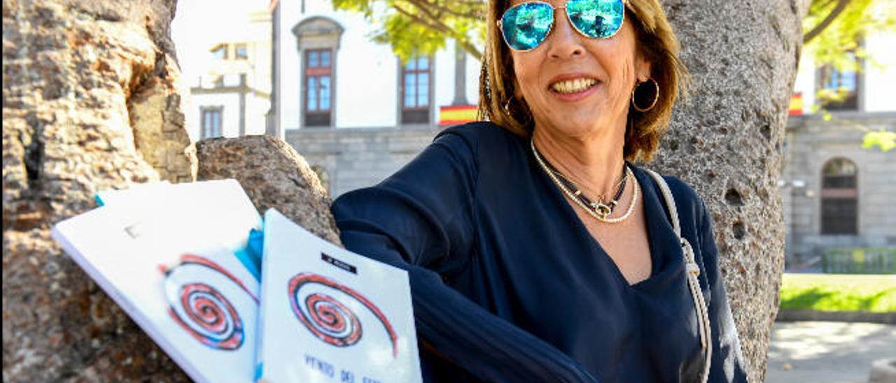 Josefa Mederos apoyada en un árbol del parque San Telmo con varios ejemplares de sus obras.