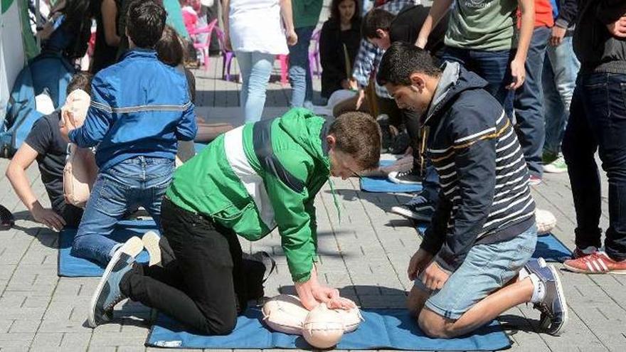 Dos adolescentes aprenden a hacer maniobras de recuperación cardiopulmonar.