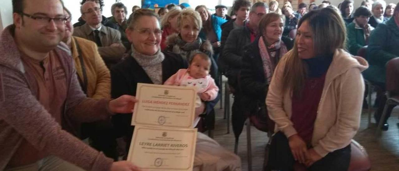 Luisa Méndez con Leyre Larriet en brazos, rodeadas de familiares y vecinos, en Villayón.