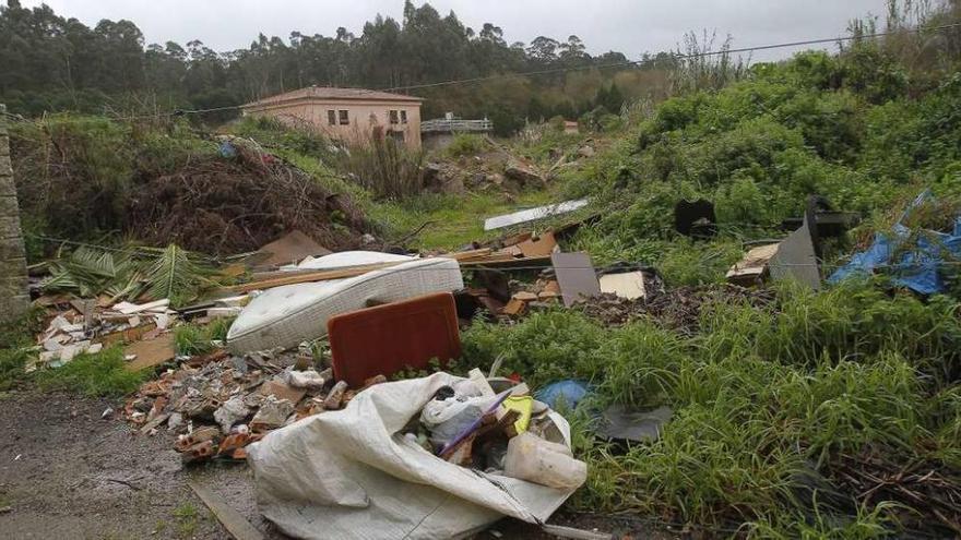 La acumulación ilegal de residuos junto a la depuradora, a pocos metros del río Muíños. // Adrián Irago