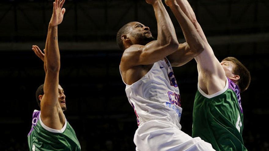 El alero estadounidense del CSKA Moscú, Cory Higgins (c), intenta encestar ante la presión del pívot estadounidense del Unicaja Jack Cooley (d).