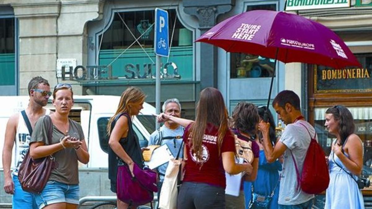 Dos guías turísticos con un grupo de viajeros, el lunes, en la plaza del Àngel.