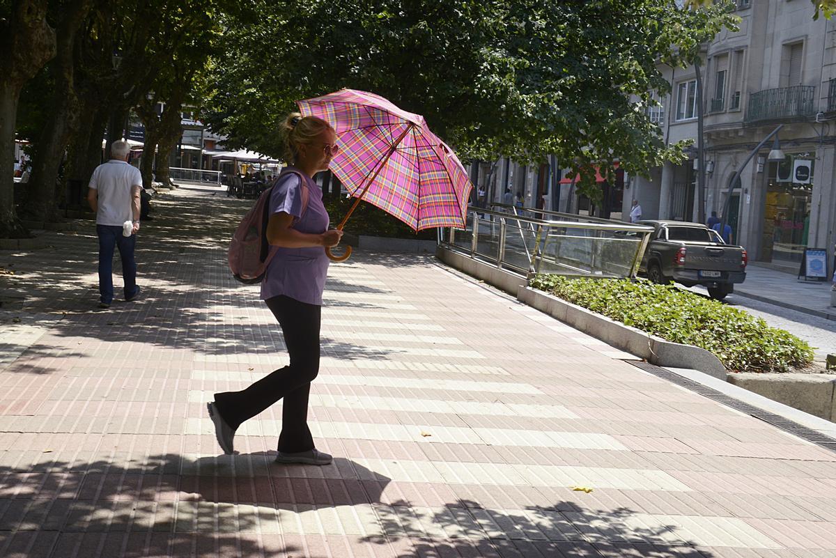 Archivo - Una mujer camina por una vía en plena ola de calor