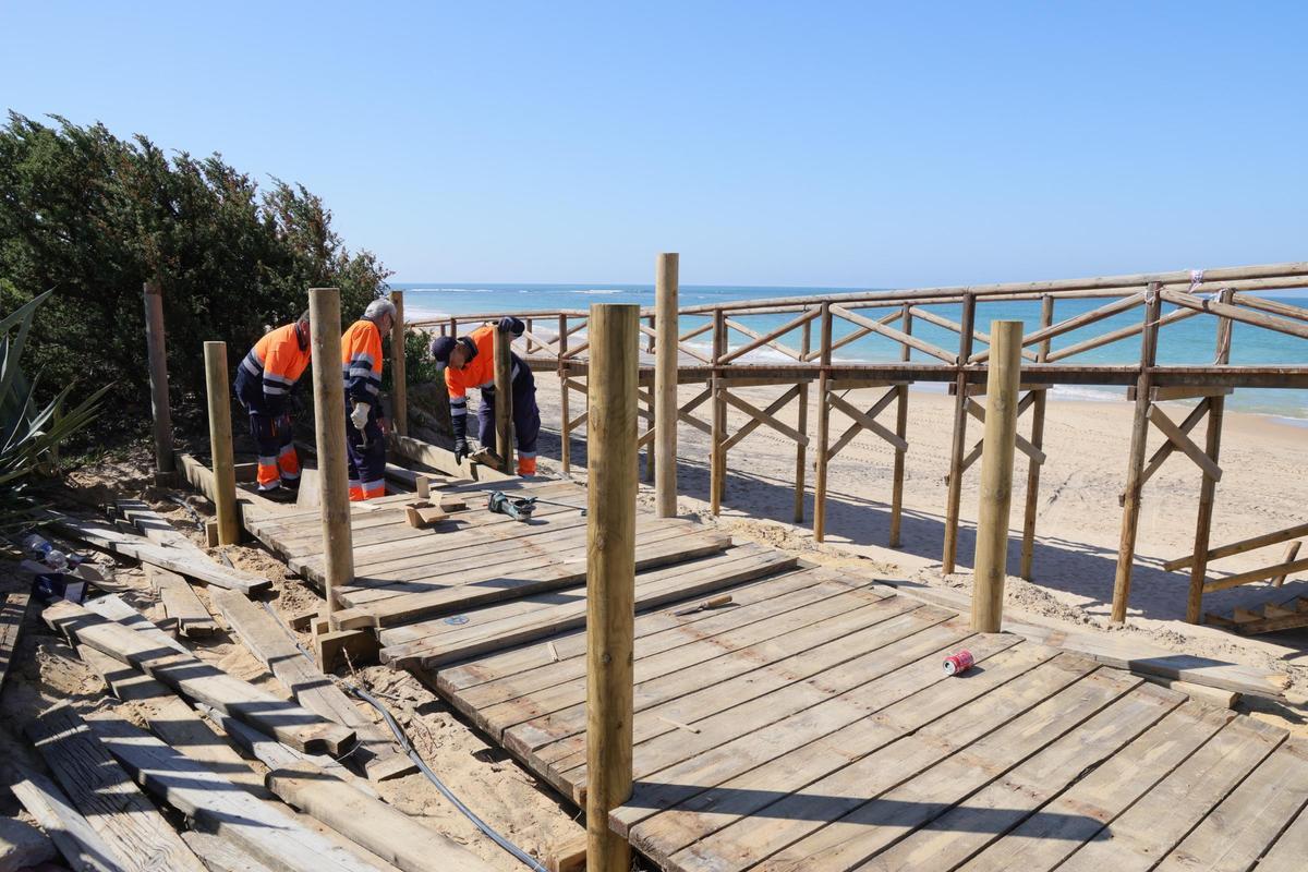 Operarios arreglando los daños causados por los temporales en la costa de Rota.