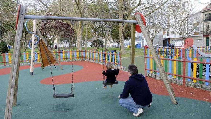 Un padre columpia a un niño en un parque.