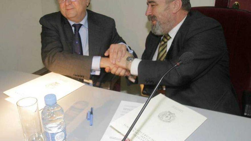 El presidente de los economistas, Ramón Madrid (i), estrecha la mano al decano de los abogados de Cartagena, José Muelas