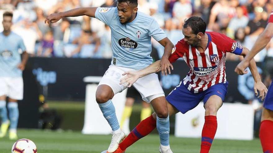 Sofiane Boufal pugna por un balón con Diego Godín durante el choque de ayer en Balaídos. // R. Grobas