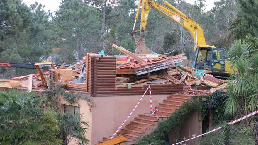 Una excavadora derriba una chalé en O Grove.