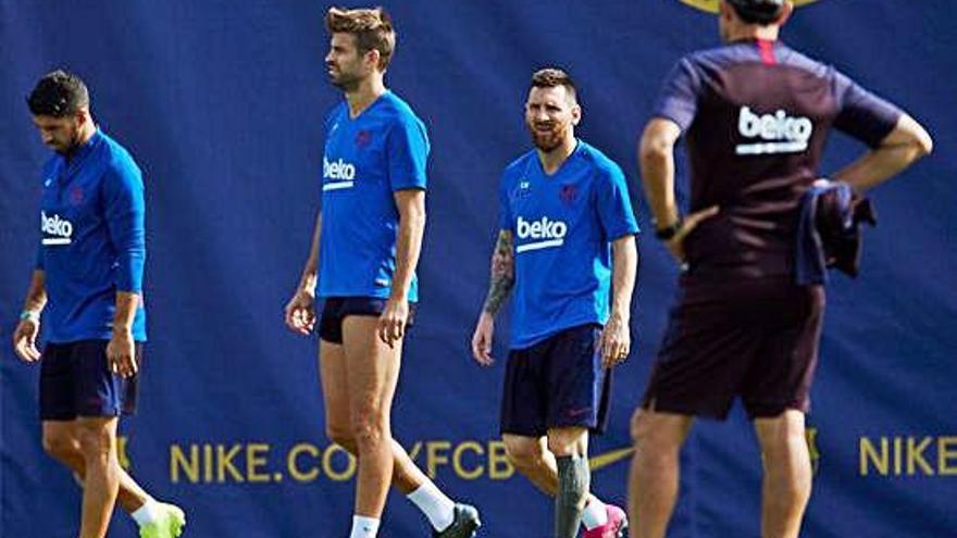 Luis Suárez, Piqué y Messi se ejercitan ayer en las instalaciones del FC Barcelona.
