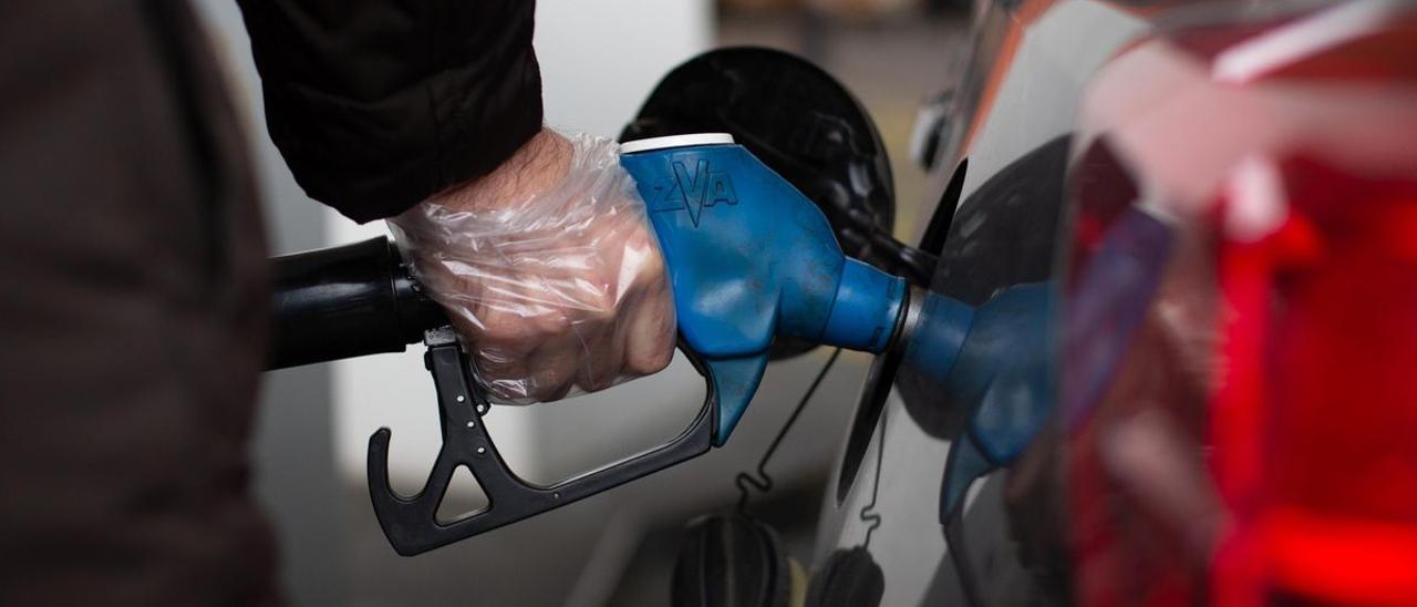 Un hombre reposta en una gasolinera.