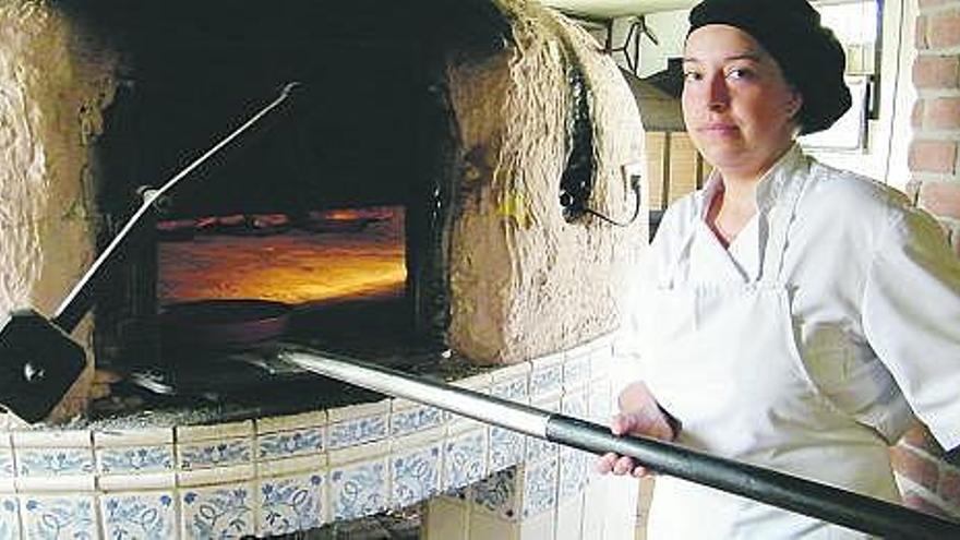 Sandra da Costa, del Asador La Miranda, trabajando en el horno.