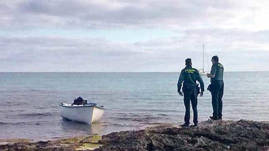 Dos guardias civiles, nada más encontrar la embarcación, en es Caló.