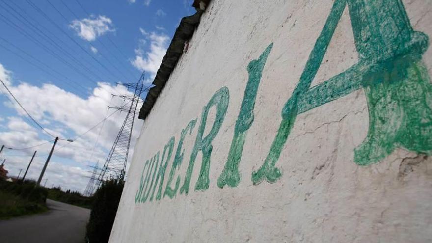 Un rótulo que anuncia una sidrería en San Cristóbal entre fincas verdes.