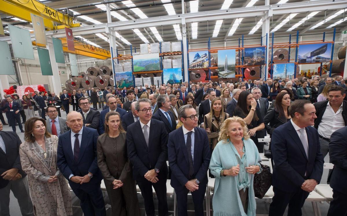 Sobre estas líneas, autoridades, en primera fila. A la derecha, el exministro José Bono. Debajo, dos trabajadores en la nave durante la visita institucional; el saludo de Manuel Villa Cellino y Teresa Sanjurjo con algunos de los invitados y, a la derecha, Alfredo Suárez y Adrián Barbón avanzan junto a una montaña de bobinas en la sede de Asturmadi.  | MIKI LÓPEZ