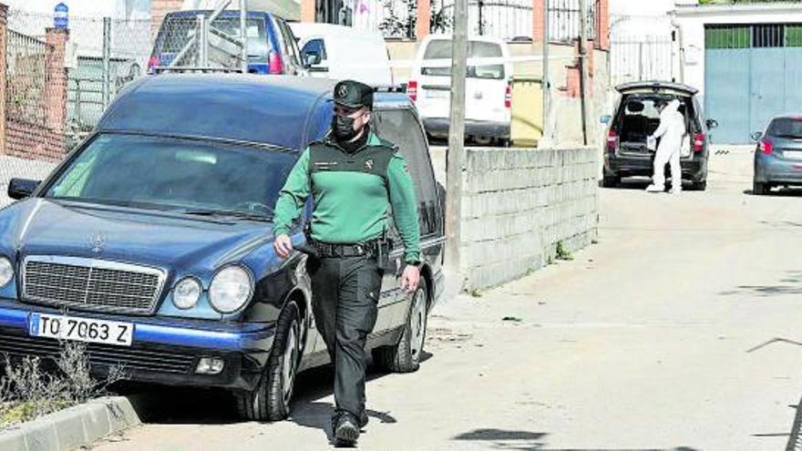 Un agente de la Guardia Civil y un coche fúnebre.   | // MIGUEL ÁNGEL MOLINA