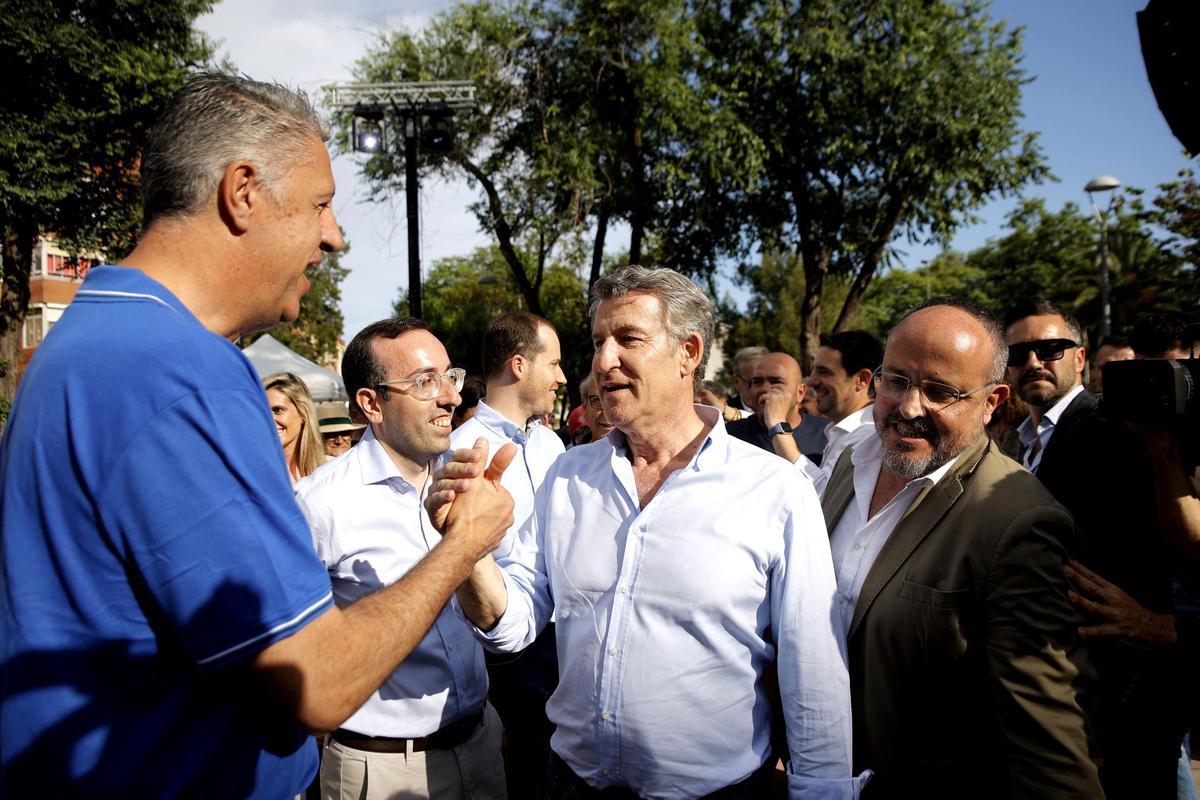 Archivo - El presidente del Partido Popular, Alberto Núñez Feijóo (c), saluda al alcalde de Badalona, Xabier García Albiol (i)