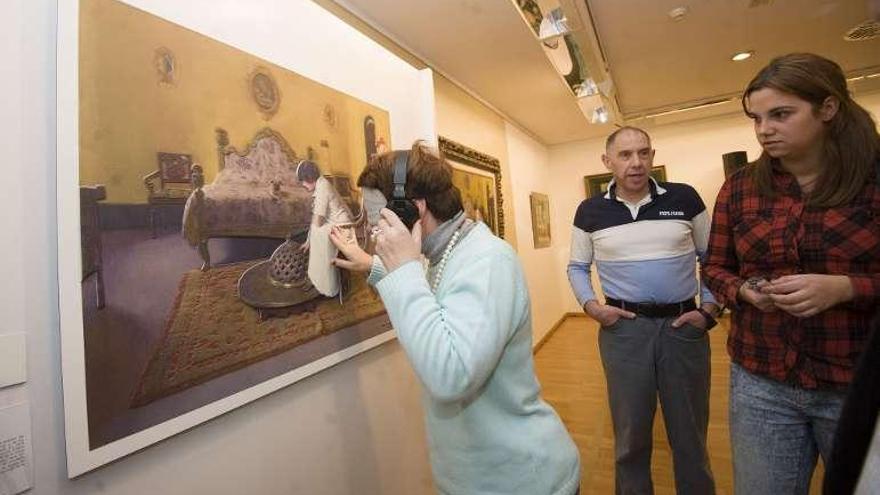 Un joven toca una obra ayer en la exposición. // 13fotos