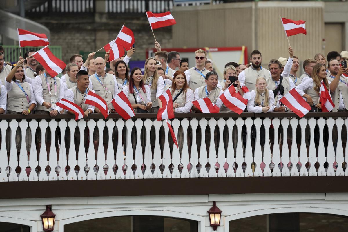 Atletas de Austria ondean su bandera nacional mientras están a bordo de un barco en el desfile flotante en el río Sena en París, Francia, durante la ceremonia de apertura de los Juegos Olímpicos