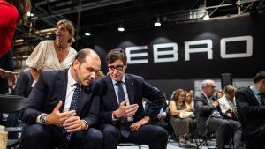 El president de la Generalitat, Salvador Illa, conversa con el conseller de Presidència, Albert Dalmau, antes del arranque de la presentación del anteproyecto de la ley de simplificación administrativa en la fábrica de Ebro en Barcelona.