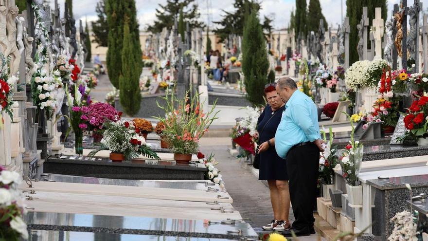 Dos personas visitan la lápida de un familiar en el cementerio de Nuestro Padre Jesús de Murcia.