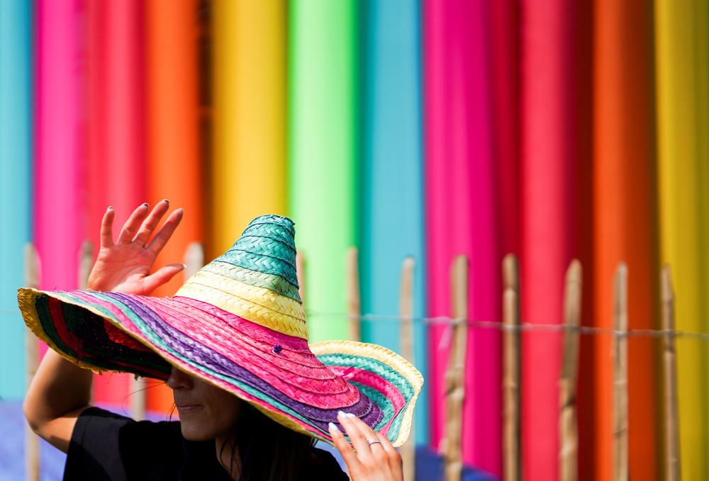 A reveller wears a rainbow coloured hat at ...