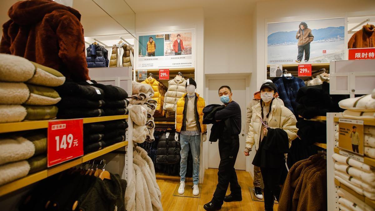 Dos personas de compras en un centro comercial en Pekín.