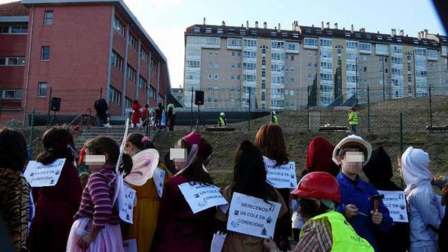 Alumnos del colegio de Os Rosales parodian, ayer, el retraso en las obras en su centro. / la opinión