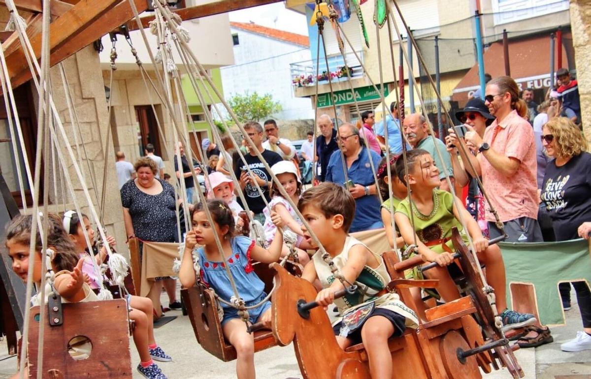 Un grupo de niños disfruta en las atracciones infantiles de esta feria gallega.