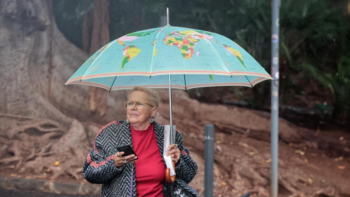 Una señora pasea bajo la lluvia en Tenerife.