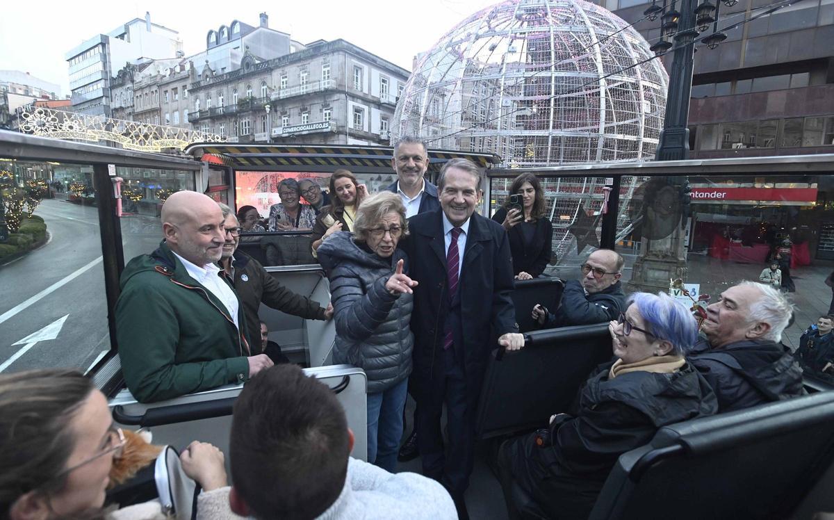 Abel Caballero (c.) atiende a turistas en el Nadal Bus junto al director de Vitrasa (i.) y el edil de Fiestas, Ángel Rivas