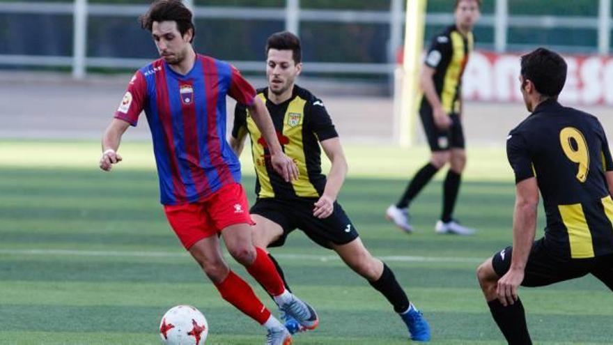 El visitante Chema Díaz conduce la pelota ante la presión de un par de rivales.