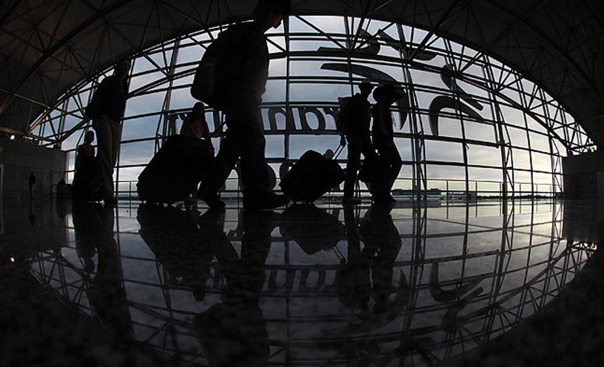 Diversos passatgers caminen per l’aeroport de Frankfurt després que els controladors aeris alemanys desconvoquessin la vaga programada per dimarts.