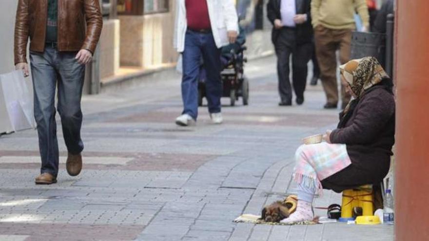 Una mujer pide en una calle de A Coruña. / víctor echave