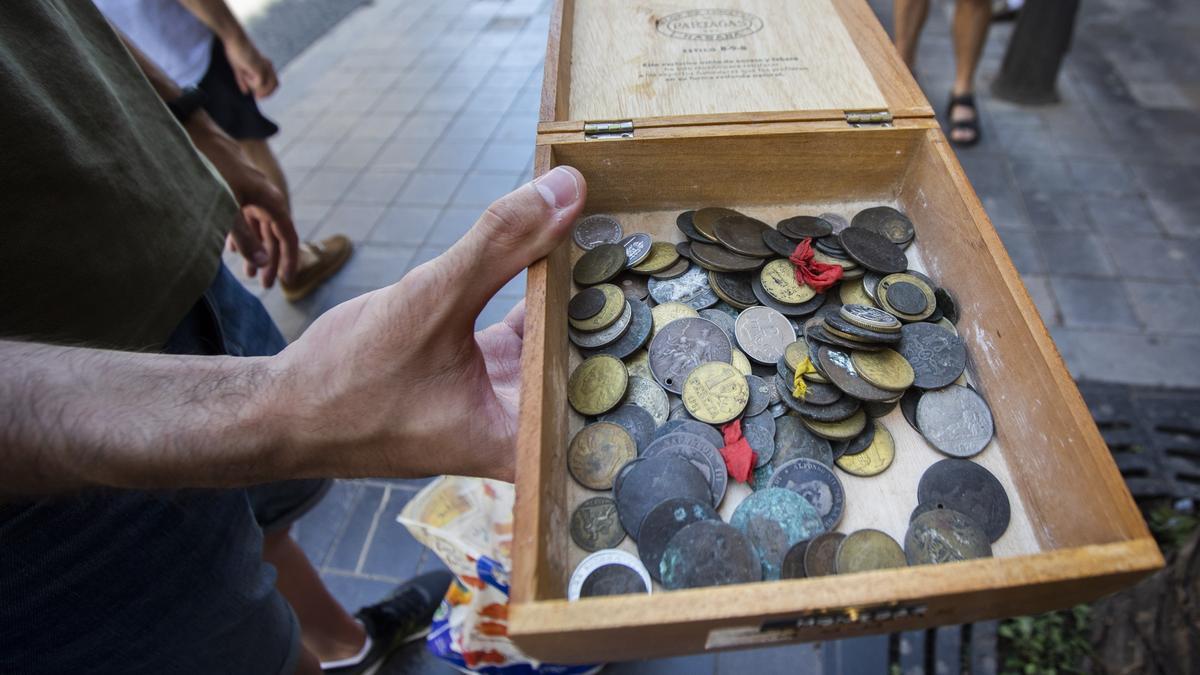 Una caja llena de pesetas de una de las personas en la cola.