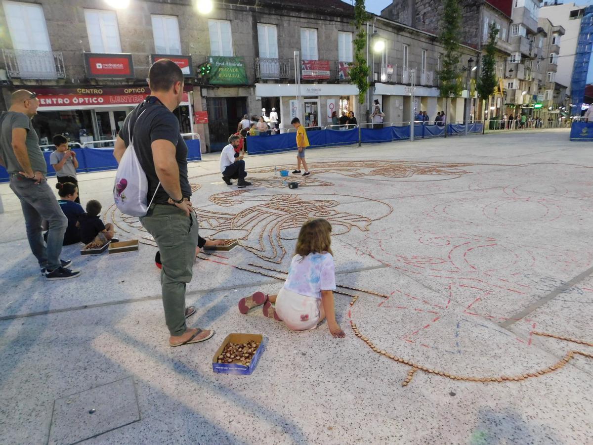 Los pequeños durante las labores de perfilado de una alfombra.