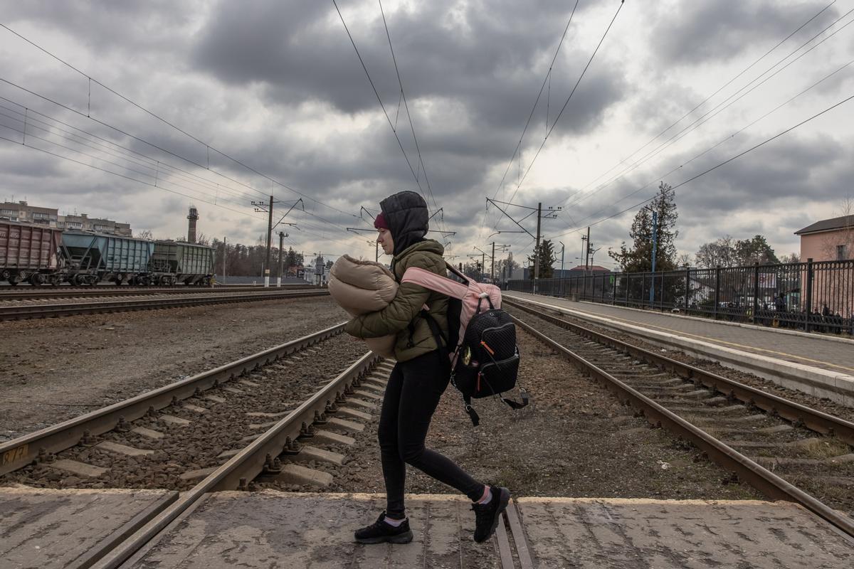 Una mujer con un bebé se dispone a subir a un tren de evacuación en la ciudad ucraniana de Kiev.