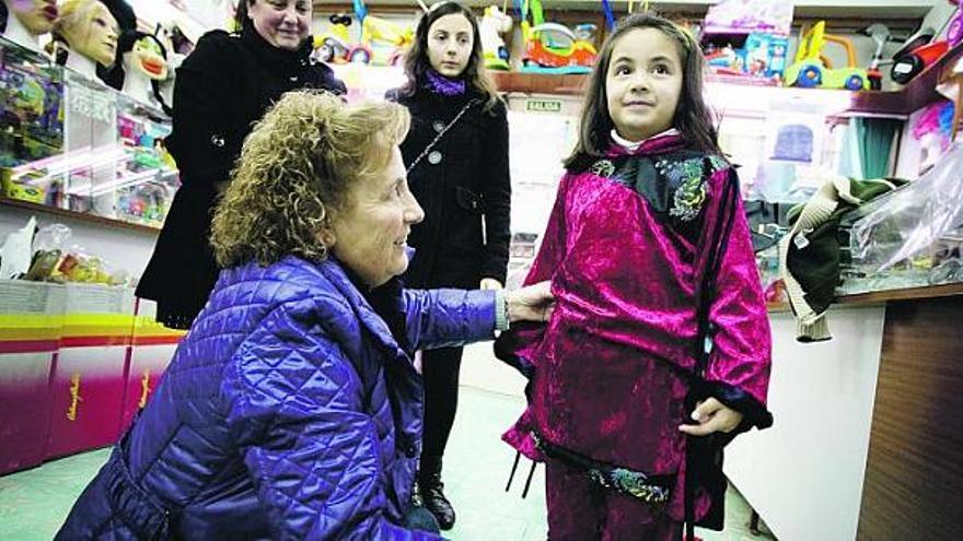 Una niña se prueba un traje de ninja en una tienda de disfraces de Avilés.