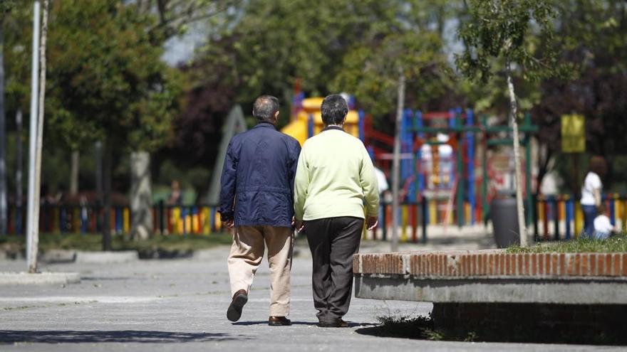 Una pareja de pensionistas pasea por la calle.