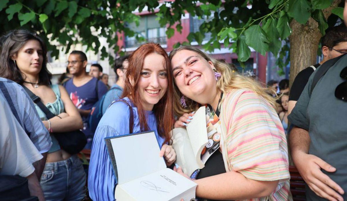 Dos seguidoras muestran orgullosas el autógrafo de Sanderson.