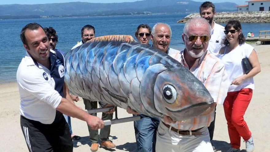 Miembros de la asociación de vecinos de Vilaxoán con la sardina obra del artista Guillermo Pedrosa // Noé Parga