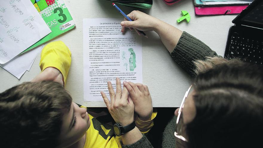 Una madre ayuda a su hijo en casa con sus estudios.