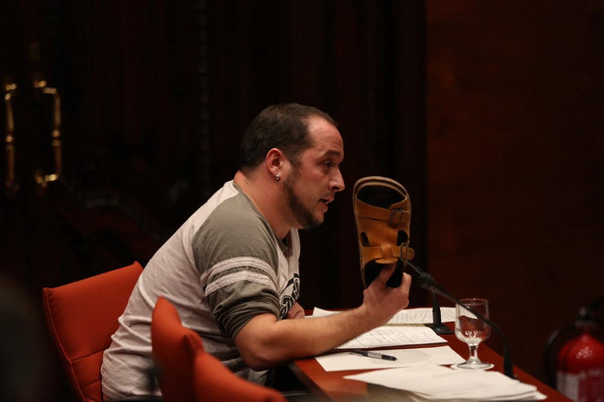 David Fernàndez, diputado de la CUP, se dirige a Rato con la sandalia en la mano.