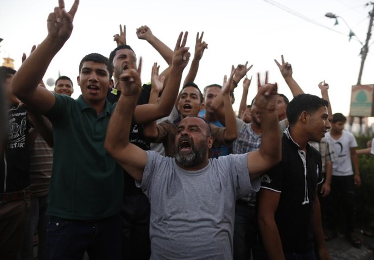 Palestinos con los brazos en alto y haciendo el símbolo de victoria