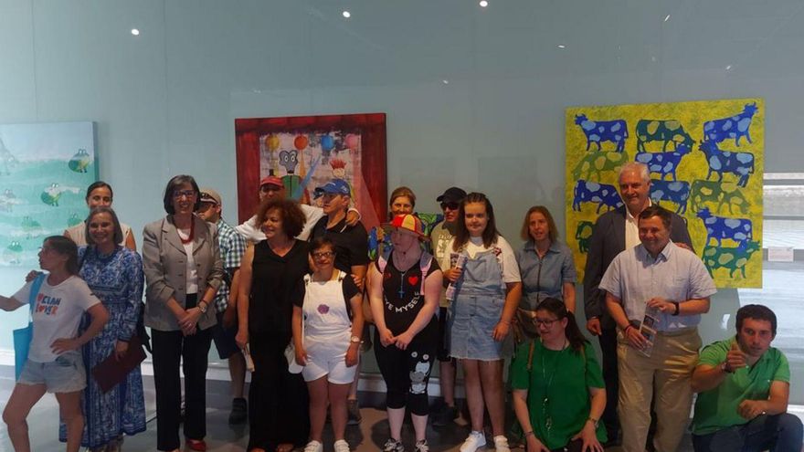 Autoridades y usuarios del centro «La Arboleya», ayer en la Antigua Rula, tras la inauguración de la exposición. | S. G.