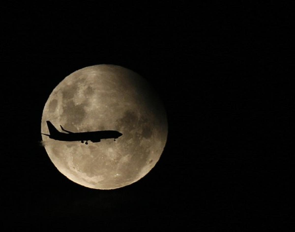Un avió de passatgers vola, amb la lluna de fons, durant el transcurs d’un eclipsi parcial, el 31 de desembre del 2009. Un avió de passatgers vola, amb la lluna de fons, durant el transcurs d’un eclipsi parcial, el 31 de desembre del 2009.