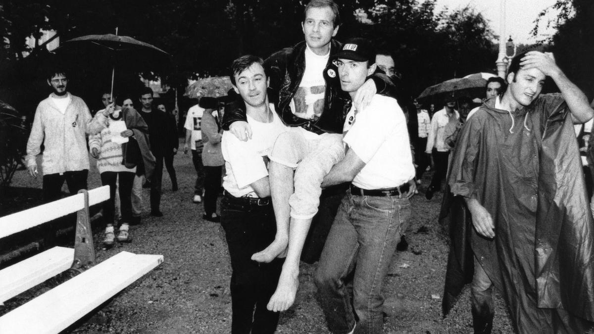 Pepe Espaliú es portado por dos voluntarios en el 'Carrying' , celebrado el 1 de diciembre de 1992 en Madrid.