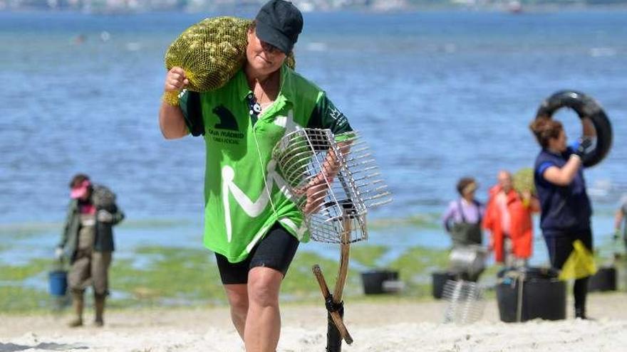 Una mariscadora carga con un saco de almejas. // Gustavo Santos