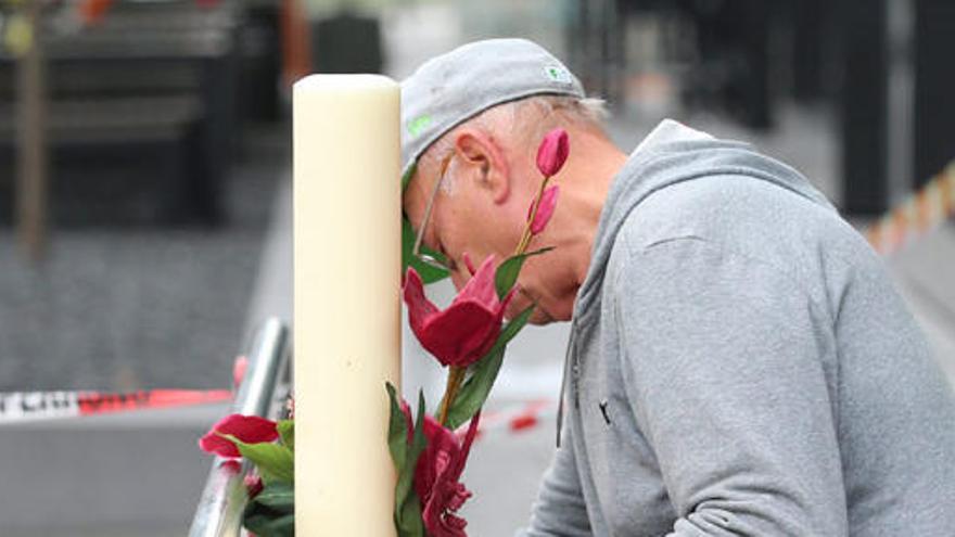 Un hombre deja flores en el lugar del tiroteo.