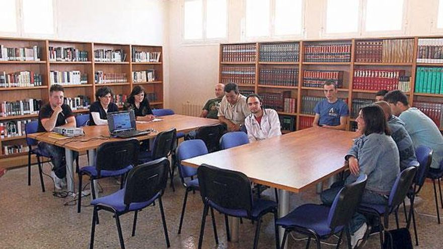 Un grupo de vecinos, en la biblioteca de Bande, sin material para un curso formativo por el robo.  // J. Regal